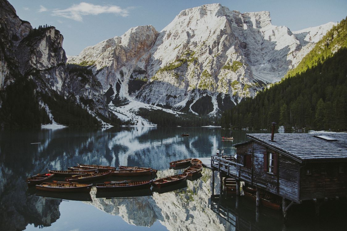 lago con vistas a la montaña y barcas en Dolomitas
